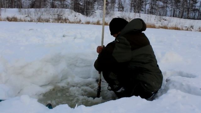 Рыбак добывает мормыши на озере в Якутии