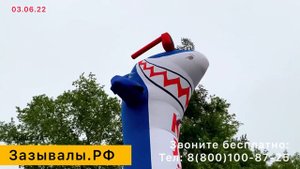 Надувная акула машет рукой.
