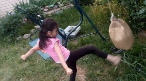 Маленькая девочка бьёт по мешку