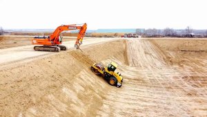 Уплотнение откосов котлована при помощи катка и экскаватора
