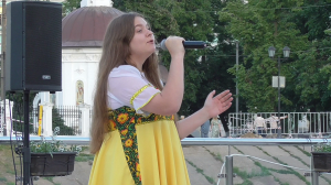 Девушка поёт песню: Матушка Россия, я верую в тебя