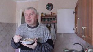 Человек кушает плов на кухне