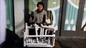 Уличный музыкант играет на водопроводных трубах Музыка Труба