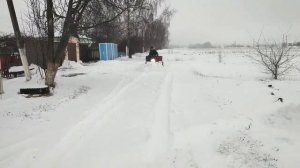 Мотороллер муравей четырехтактным двигателем чистит снег.