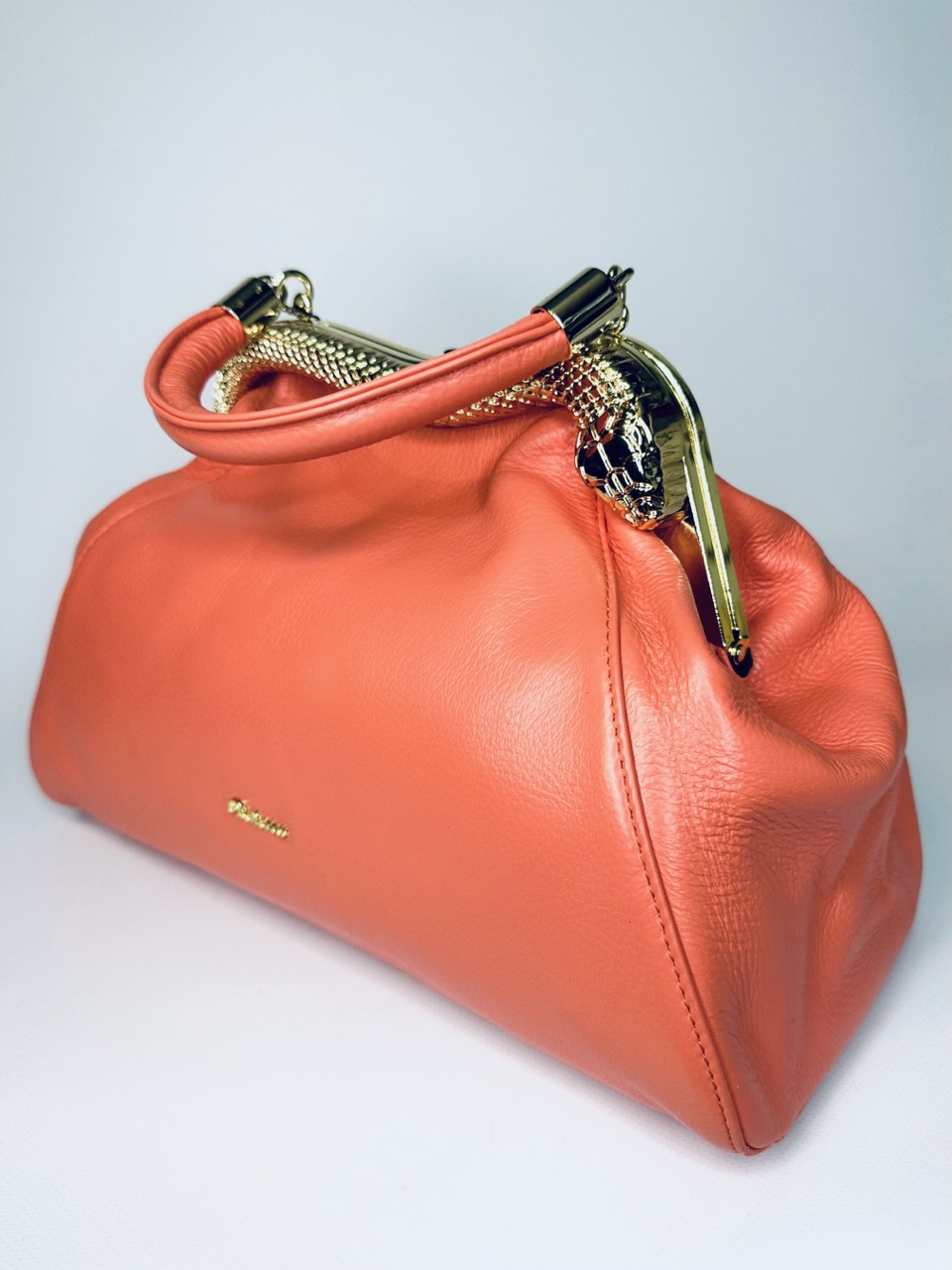 Женская кожаная сумка саквояж на плечо красивого кораллового цвета с золотым фермуаром в виде змеи