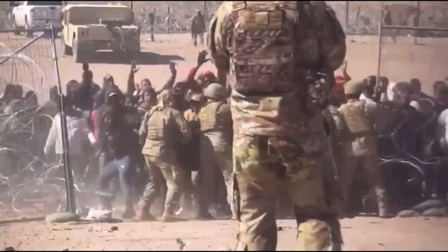 Толпа нелегалов прорывается через несколько рядов колючей проволоки на американо-мексиканской границ