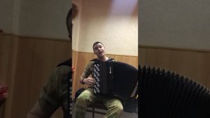 Солдат в армии поёт и играет на баяне