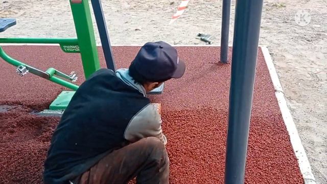 укладка резинового покрытия на спортплощадке.