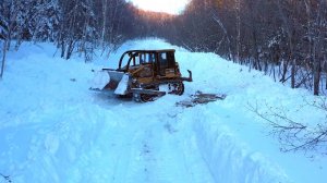 Бульдозер "Caterpillar" D6G пробивает в глубоком снегу лесовозную дорогу